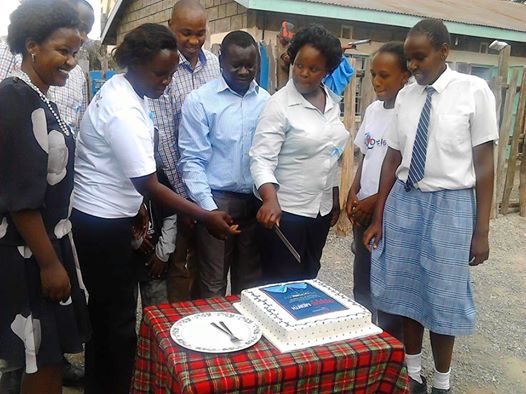 Guests and children of Rare Gem Talent School at Dyslexia Awareness Month event, cutting a cake to celebrate the awareness month on 31st October 2015.